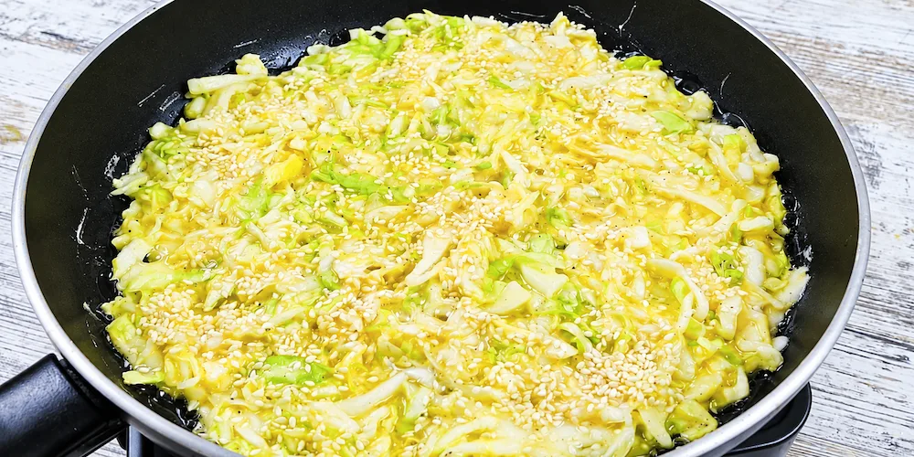 Капустяна маса з яйцями та кунжутом на сковороді